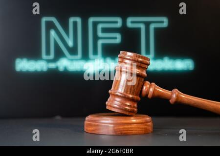 Konzept der NFT- oder nicht fungiblen Token-Auktion oder des Gebots mit einem Auktionshammer mit NFT im Hintergrund Stockfoto