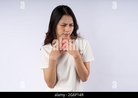 Porträt einer asiatischen Frau mit Halsschmerzen isoliert auf weißem Hintergrund Stockfoto