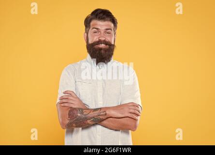 Charismatischer Kerl, der glücklich aussieht. Barbier-Mode. Haar- und Bartpflege. Bärtiger Koch im weißen Hemd. Brutaler kaukasischer Hipster mit Schnurrbart Stockfoto