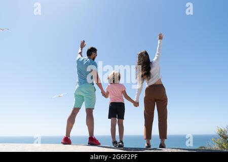 Lebensversicherung. Adoption und Erfolg. Rückansicht. Vater Mutter und Kind im Sommer. Stockfoto