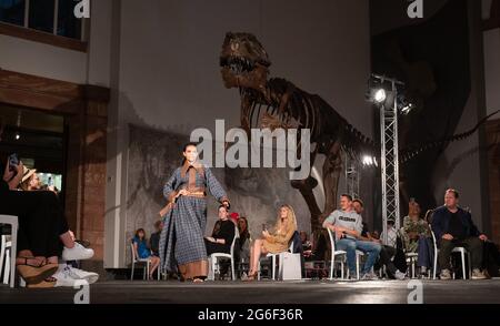 05. Juli 2021, Hessen, Frankfurt/M.: Während der Modenschau des Designers Samuel Gärtner im Senckenberg Museum läuft ein Modell vor dem Skelett eines Tyrannosaurus. Die Modenschau findet zu Beginn der Frankfurter Fashion Week statt, die vom 5. Bis 9. Juli stattfindet. Es ist jedoch nicht Teil des offiziellen Programms. Foto: Sebastian Gollnow/dpa Stockfoto