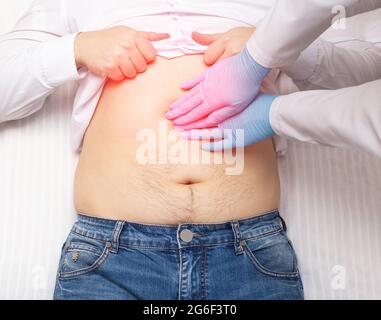 Der Arzt untersucht einen Patienten, der Bauchschmerzen hat. Konzept der Pankreas-Entzündung, Pankreatitis, Nahaufnahme. Entzündung der Gallenblase und Duode Stockfoto