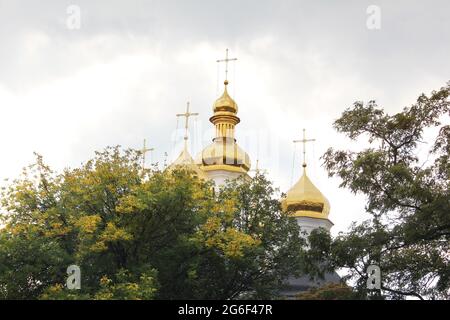 Schöne Kirche im Park. Goldene Kuppeln. Herbst Stockfoto