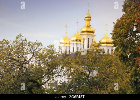 Schöne Kirche im Park. Goldene Kuppeln. Herbst Stockfoto