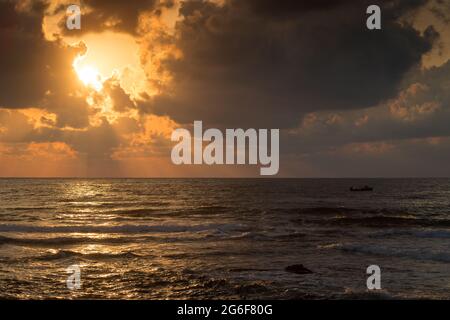 Dramatischer Sonnenaufgang über dem Meer mit Wolken und Sonnenstrahlen Stockfoto