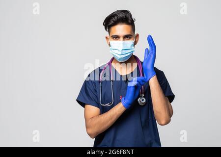 Der indische Arzt zieht Handschuhe an und trägt eine medizinische Maske. Medizinisches Konzept Corona Virus Stockfoto