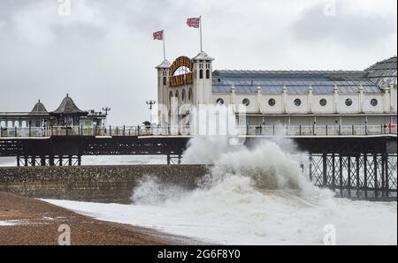 Brighton UK 6. Juli 2021 - Wellen schlagen am Brighton Palace Pier ein, als starke Winde die Südküste heute Morgen mit Böen von bis zu 40 Meilen pro Stunde für einige Gebiete schlagen : Credit Simon Dack / Alamy Live News Stockfoto