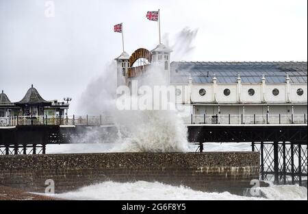 Brighton UK 6. Juli 2021 - Wellen schlagen am Brighton Palace Pier ein, als starke Winde die Südküste heute Morgen mit Böen von bis zu 40 Meilen pro Stunde für einige Gebiete schlagen : Credit Simon Dack / Alamy Live News Stockfoto