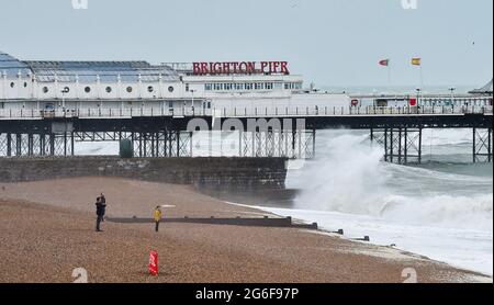 Brighton UK 6. Juli 2021 - Wellen schlagen am Brighton Palace Pier ein, als starke Winde die Südküste heute Morgen mit Böen von bis zu 40 Meilen pro Stunde für einige Gebiete schlagen : Credit Simon Dack / Alamy Live News Stockfoto