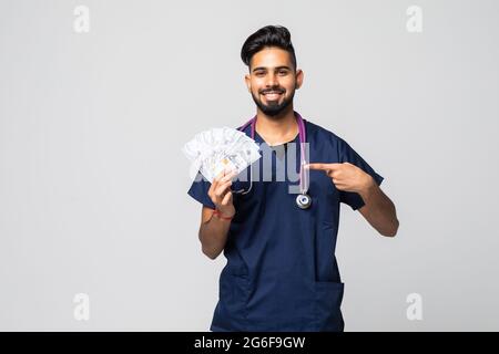 Junger Arzt mit einem Haufen von 1-Dollar-Banknoten vor isoliertem Hintergrund Stockfoto