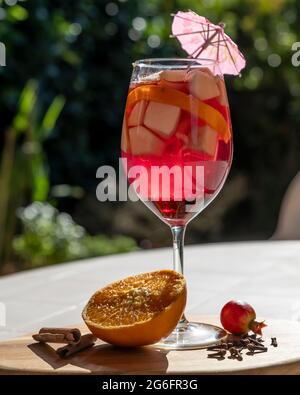 Ein leckeres Glas Sangria mit Fruchtstücken im Hintergrund Stockfoto