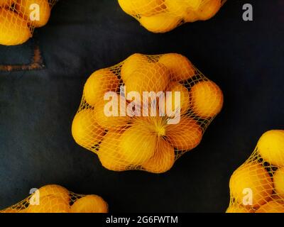 Zitronen. Zitronen im Netz. Zitrone am Gemüsehändler. Stockfoto