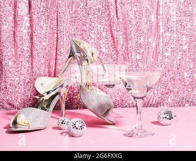 Martini-Cocktail auf dem Hintergrund eines rosa glänzenden Vorhangs. Das Konzept eines Urlaubs, einer Party, eines Nachtclubs Stockfoto