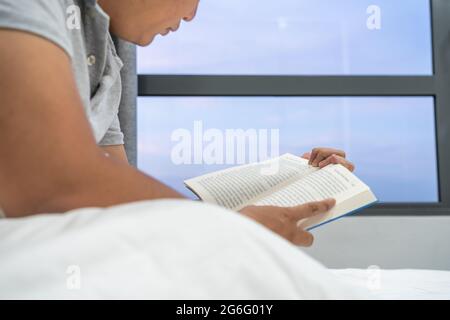 Mann liest Bücher in seinem Hotelzimmer Stockfoto
