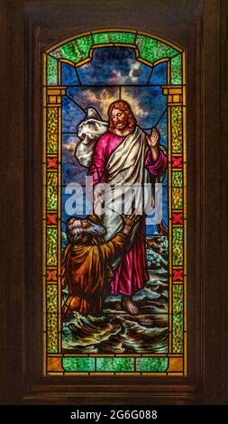 Glasmalerei in der katholischen Kirche St. Joseph, die das Wunder von Jesus darstellt, der auf dem Wasser geht und Petrus zu Jesus ruft: 'Herr, rette mich.' Stockfoto