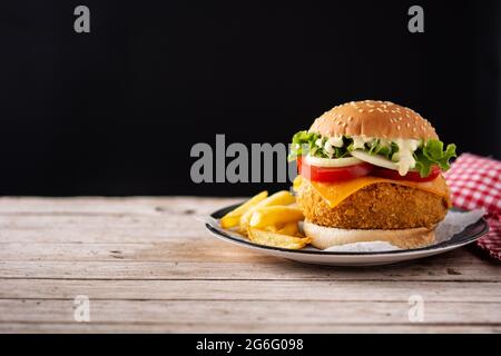 Knuspriger Hähnchenburger mit Käse auf Holztisch Stockfoto