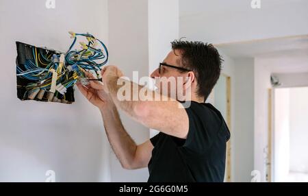 Elektriker, der an der elektrischen Installation eines Hauses arbeitet Stockfoto