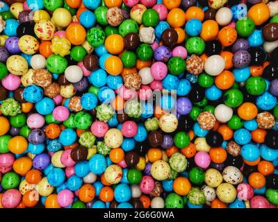 Farbige runde Schokolade aus nächster Nähe. Hintergrund von kleinen farbigen Pralinen und Detailaufnahmen. Stockfoto