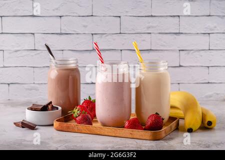 Set aus Erdbeerbanane und Schokoladenmilchshakes in den Gläsern Stockfoto