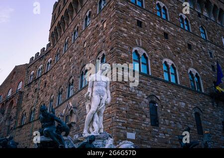 Neptun-Brunnen mit Marmorskulptur vor den rustikalen Steinmauern des Palazzo Vecchio. Florenz, Italien. Stockfoto