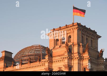 Im ersten Morgenlicht schwenkt die deutsche Flagge auf den Reichstag, Deutschland, Berlin Stockfoto