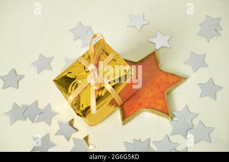 goldenes Geschenk mit Schleife und Sternen als Weihnachtsdekoration Stockfoto