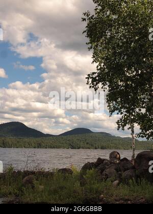 Indian Lake, New York im Adirondack State Park mit Mondaufgang und Blick auf das Ufer des Indian Lake. Stockfoto