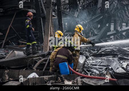 Bang Phli, Thailand. Juli 2021. Thailändische Feuerwehrleute löschen einen Brand, der durch eine Explosion in einer von einem Brand heimgetragenen Ming Dih Chemical Fabrik im Bezirk Bang Phli, Provinz Samut Prakan, verursacht wurde.bei einer Explosion über Nacht und einem Brand in einer Chemiefabrik wurde eine Person getötet und mehr als 60 weitere verletzt. Am späten Montagnachmittag sendend schwarzer Rauch über Samut Prakans Bang Phli-Gebiet in den Himmel. Feuerwehrleute verwendeten Hubschrauber, darunter auch einige von der Armee, um flammhemmenden Schaum über den brennenden Ming Dih Chemical Co-Anlagenkomplex zu sprühen. Kredit: SOPA Images Limited/Alamy Live Nachrichten Stockfoto