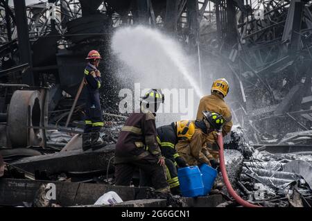 Bang Phli, Thailand. Juli 2021. Thailändische Feuerwehrleute löschen einen Brand, der durch eine Explosion in einer von einem Brand heimgetragenen Ming Dih Chemical Fabrik im Bezirk Bang Phli, Provinz Samut Prakan, verursacht wurde.bei einer Explosion über Nacht und einem Brand in einer Chemiefabrik wurde eine Person getötet und mehr als 60 weitere verletzt. Am späten Montagnachmittag sendend schwarzer Rauch über Samut Prakans Bang Phli-Gebiet in den Himmel. Feuerwehrleute verwendeten Hubschrauber, darunter auch einige von der Armee, um flammhemmenden Schaum über den brennenden Ming Dih Chemical Co-Anlagenkomplex zu sprühen. Kredit: SOPA Images Limited/Alamy Live Nachrichten Stockfoto