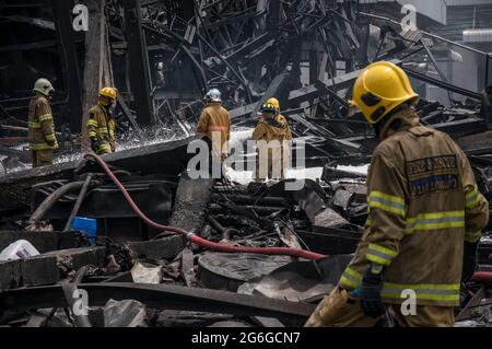 Bang Phli, Thailand. Juli 2021. Thailändische Feuerwehrleute löschen einen Brand, der durch eine Explosion in einer von einem Brand heimgetragenen Ming Dih Chemical Fabrik im Bezirk Bang Phli, Provinz Samut Prakan, verursacht wurde.bei einer Explosion über Nacht und einem Brand in einer Chemiefabrik wurde eine Person getötet und mehr als 60 weitere verletzt. Am späten Montagnachmittag sendend schwarzer Rauch über Samut Prakans Bang Phli-Gebiet in den Himmel. Feuerwehrleute verwendeten Hubschrauber, darunter auch einige von der Armee, um flammhemmenden Schaum über den brennenden Ming Dih Chemical Co-Anlagenkomplex zu sprühen. Kredit: SOPA Images Limited/Alamy Live Nachrichten Stockfoto