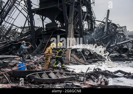 Bang Phli, Thailand. Juli 2021. Thailändische Feuerwehrleute löschen einen Brand, der durch eine Explosion in einer von einem Brand heimgetragenen Ming Dih Chemical Fabrik im Bezirk Bang Phli, Provinz Samut Prakan, verursacht wurde.bei einer Explosion über Nacht und einem Brand in einer Chemiefabrik wurde eine Person getötet und mehr als 60 weitere verletzt. Am späten Montagnachmittag sendend schwarzer Rauch über Samut Prakans Bang Phli-Gebiet in den Himmel. Feuerwehrleute verwendeten Hubschrauber, darunter auch einige von der Armee, um flammhemmenden Schaum über den brennenden Ming Dih Chemical Co-Anlagenkomplex zu sprühen. Kredit: SOPA Images Limited/Alamy Live Nachrichten Stockfoto