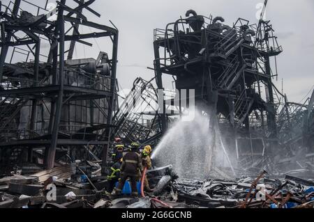 Bang Phli, Thailand. Juli 2021. Thailändische Feuerwehrleute löschen einen Brand, der durch eine Explosion in einer von einem Brand heimgetragenen Ming Dih Chemical Fabrik im Bezirk Bang Phli, Provinz Samut Prakan, verursacht wurde.bei einer Explosion über Nacht und einem Brand in einer Chemiefabrik wurde eine Person getötet und mehr als 60 weitere verletzt. Am späten Montagnachmittag sendend schwarzer Rauch über Samut Prakans Bang Phli-Gebiet in den Himmel. Feuerwehrleute verwendeten Hubschrauber, darunter auch einige von der Armee, um flammhemmenden Schaum über den brennenden Ming Dih Chemical Co-Anlagenkomplex zu sprühen. Kredit: SOPA Images Limited/Alamy Live Nachrichten Stockfoto