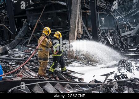 Bang Phli, Thailand. Juli 2021. Thailändische Feuerwehrleute löschen einen Brand, der durch eine Explosion in einer von einem Brand heimgetragenen Ming Dih Chemical Fabrik im Bezirk Bang Phli, Provinz Samut Prakan, verursacht wurde.bei einer Explosion über Nacht und einem Brand in einer Chemiefabrik wurde eine Person getötet und mehr als 60 weitere verletzt. Am späten Montagnachmittag sendend schwarzer Rauch über Samut Prakans Bang Phli-Gebiet in den Himmel. Feuerwehrleute verwendeten Hubschrauber, darunter auch einige von der Armee, um flammhemmenden Schaum über den brennenden Ming Dih Chemical Co-Anlagenkomplex zu sprühen. Kredit: SOPA Images Limited/Alamy Live Nachrichten Stockfoto