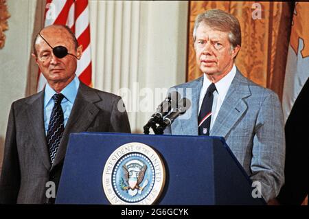 US-Präsident Jimmy Carter, rechts, kündigt am Donnerstag, dem 12. Oktober 1977, im Ostsaal des Weißen Hauses in Washington, DC, Friedensgespräche zwischen der Arabischen Republik Ägypten und dem Staat Israel an. Die Gespräche werden in den Abkommen von Camp David gefordert, die am 17. September 1978 von Präsident Carter, dem ägyptischen Präsidenten Anwar Sadat und Premierminister Menachem Begin von Israel unterzeichnet wurden. Links steht der israelische Außenminister Moshe Dayan.Quelle: Benjamin E. 'Gene' Forte/CNP/Sipa USA Quelle: SIPA USA/Alamy Live News Stockfoto