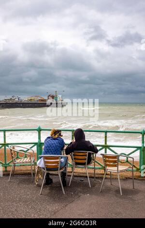 Brighton UK 6. Juli 2021 - Besucher beobachten heute Morgen das Meer in Brighton mit Böen von bis zu 40 Meilen pro Stunde für einige Gebiete : Credit Simon Dack / Alamy Live News Stockfoto