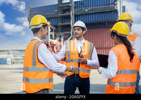 Business Logistics Konzept, Vorarbeiter steuern Ladecontainer Box des Frachtschiffes für die logistische Planung und erklären die Arbeit an das Team der Vielfalt Stockfoto