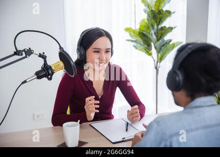 Asiatische weibliche und männliche Podcaster machen Audio-Podcast im Heimstudio Stockfoto