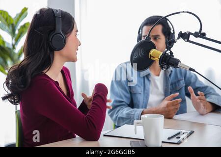 Asiatische weibliche und männliche Podcaster machen Audio-Podcast im Heimstudio Stockfoto