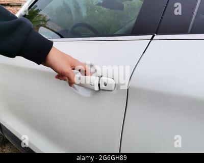 Die Autotür kann von Hand geöffnet werden. Weißes Auto. Mit dem Auto. Stockfoto