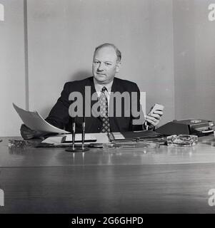 1970s, historischer, geeigneter Geschäftsführer, der mit einem handgehaltenen Diktat- oder Tonaufnahmegerät an seinem Schreibtisch sitzt, England, Großbritannien. Stockfoto