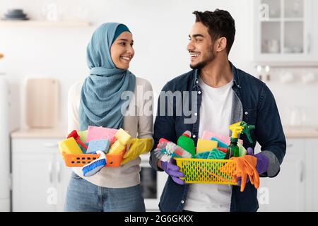 Glückliche muslimische Familie putzt ihre neue Wohnung Stockfoto