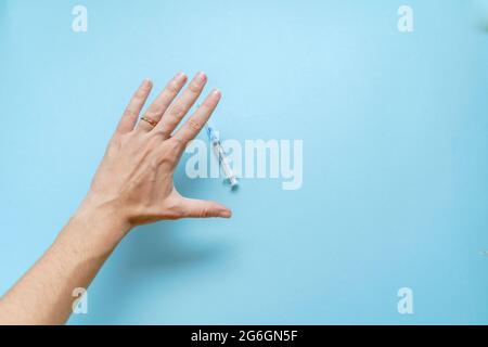 Draufsicht auf das Konzept der Impfstoffabfalle. Die Hand stoppt die Impfstoffinjektion. Ativax-Bewegung. Nebenwirkungen Angst. Anti-Impfkampagne Stockfoto