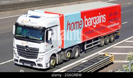 Seite & Vorderansicht Startseite Schnäppchen Werbung auf der Lieferkette des Ladens artikulierter Anhänger hinter dem weißen LKW-Logistik-LKW auf der britischen Autobahn Stockfoto