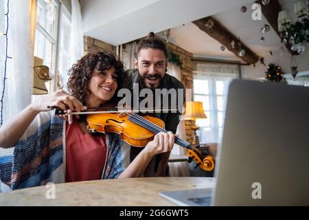 Geigenlehrerin hilft einer Schülerin zu Hause Stockfoto