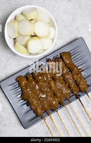 Hähnchensatay (Sate ayam) mit Lontong und Erdnusssauce Stockfoto