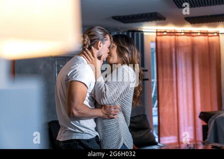 Innen Haus paar Schießen tanzen im Wohnzimmer Spaß haben, küssen - Gelb und blaues Licht. Leidenschaftliche Küsse von Liebhabern Schuss Tanz flirten genießen Stockfoto