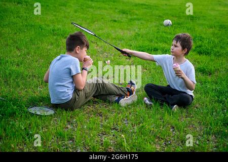 Kinder im Urlaub nach dem Sport auf dem Park Rasen, grünes Gras Stockfoto