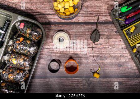 Herstellung von festen Taschen bereit für eine Karpfen Angelsitzung. Rig Herstellung von Ausrüstung auf einer hölzernen Tischplatte Stockfoto