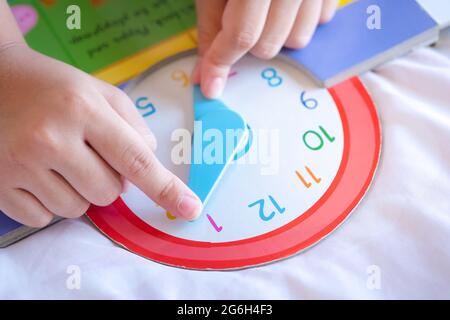 Kind spielen sagen Zeit Spiel, kleine Kinder zu lernen, wie man eine analoge Uhr zu lesen. Stockfoto