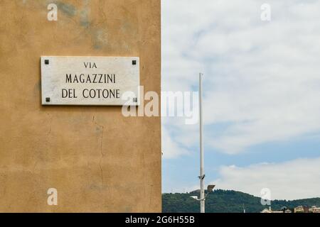 Straßenschild der Via Magazzini del Cotone (Cotton Warehouses Street, 1889-1926) im Alten Hafen (Porto Antico) von Genua, Ligurien, Italien Stockfoto